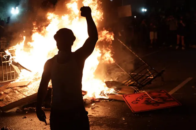 Demonstrators stand around a fire during a protest near the White House in response to the killing of George Floyd