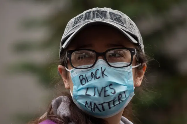 A demonstrator wears a Black Lives Matter mask during a gathering to protest the recent death of George Floyd on May 31, 2020 in Seattle, Washington