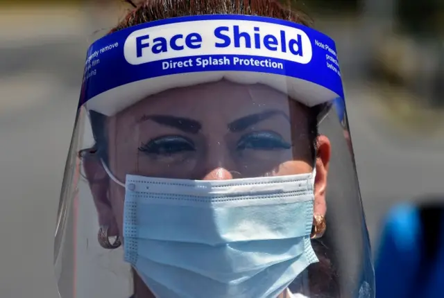 A health worker of the La Raza Hospital wears a face shield and surgical mask as she demonstrates in Mexico City on 27 April