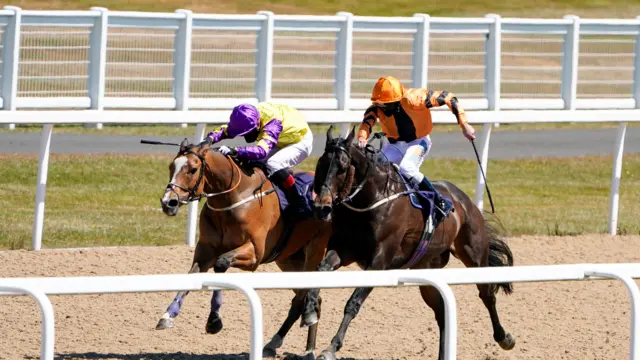 James Sullivan riding Zodiakos (in orange) wins The Welcome Back British Racing Handicap at Newcastle Racecourse