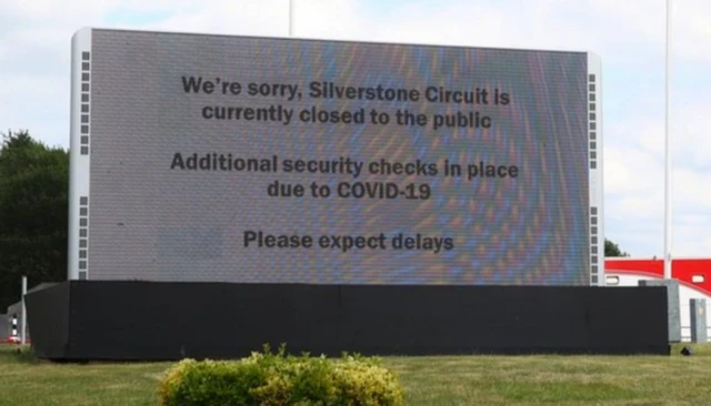 A sign reading we're sorry, silverstone circuit is currently closed to the public. Additional security checks in place due to covid-19. Please expect delays.