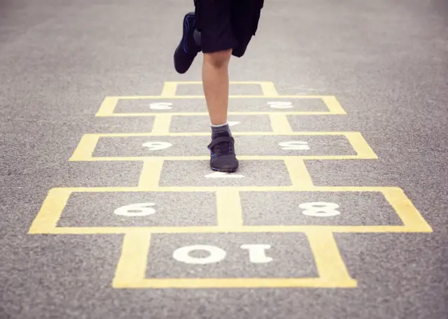 Child playing hopscotch on school playground