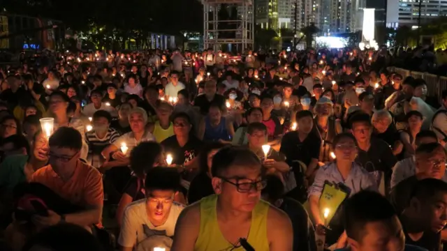 People in Hong Kong hold candles to commemorate the killings