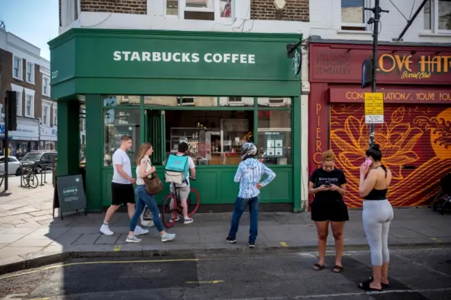 People queue outside a Starbucks coffee shop in Portobello Market in west London in June 2020