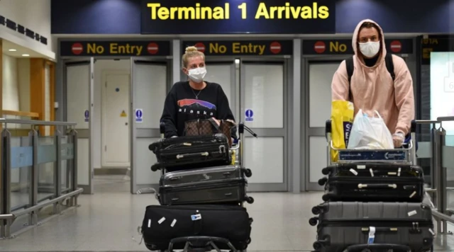 Couple reaching arrivals at a UK airport