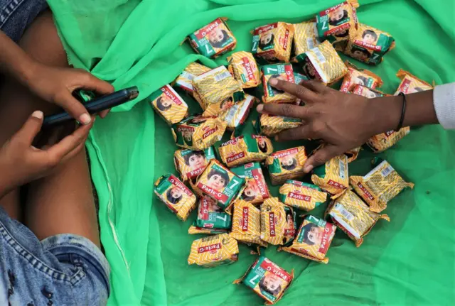 Kids playing with packs of Parle-G biscuits in India