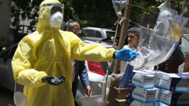 A mannequin dressed in medical protective gears stands in front of roadside stall selling face masks in Cairo, Egypt, 10 June 2020