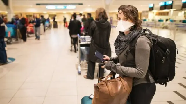 Woman at an airport wearing a mask