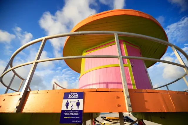 Social distancing signage is displayed on the side of the tenth street lifeguard stand on South Beach, June 10, 2020 in Miami Beach, Florida