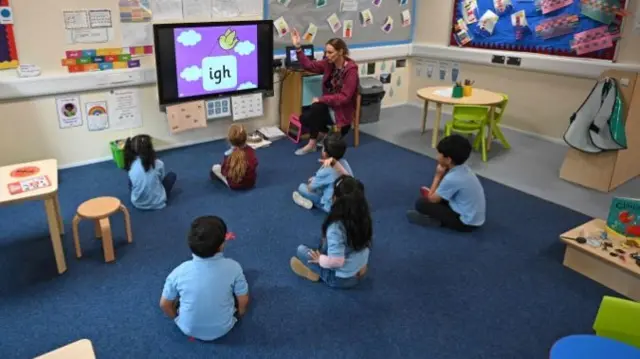 A teacher teaching a small class of children, under social-distancing guidelines, at a primary school in Huddersfield