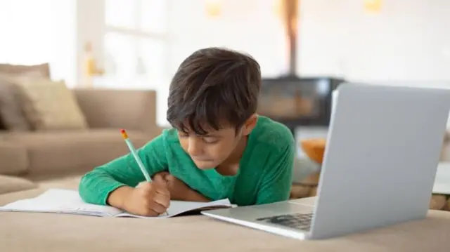 Child working at home on laptop