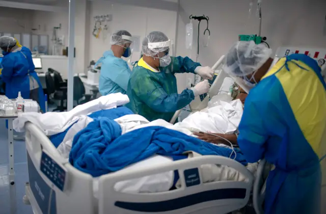 Health professionals check a patient infected with COVID-19 at the Intensive Care Unit (ICU) of the Doctor Ernesto Che Guevara Public Hospital in Marica, Rio de Janeiro state