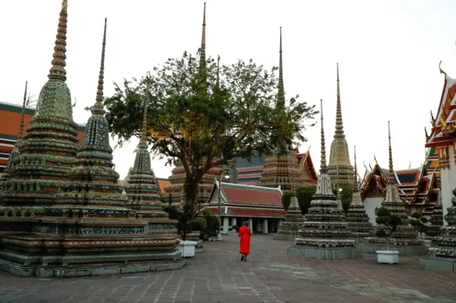 A monk walks alone at Wat Pho temple in Bangkok. Photo: March 2020
