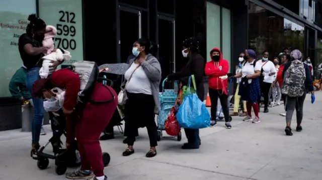People wait in line to get care packages with food donations from the Food Bank for New York City in Brooklyn, New York, New York, USA, 15 May 2020.