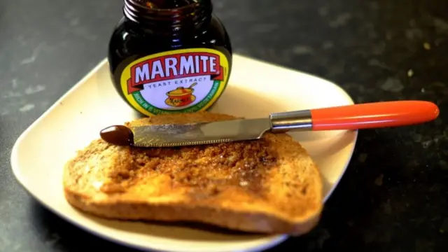 A slice of toast next to a jar of Marmite
