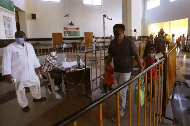 Passengers arrive at a train station as Pakistan Railways partially resumes operation, Lahore, Pakistan, 20 May 2020.