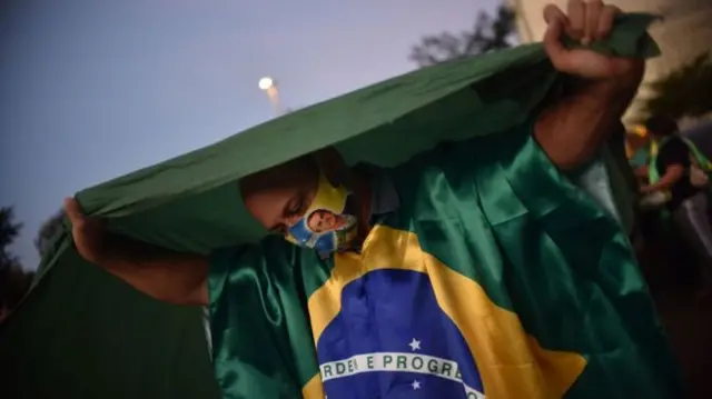 Bolsonaro supporter holds a Brazilian flag