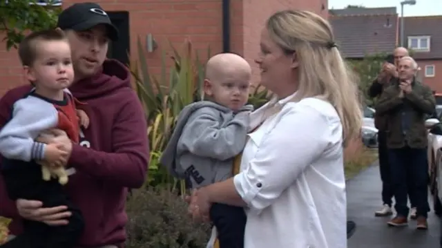 James Stephenson (left) and his son Oliver (centre) received a round of applause as they returned home from hospital