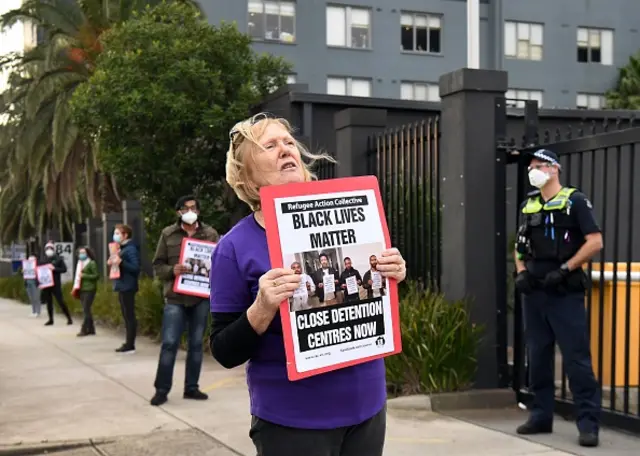 A woman holds up a placard during a pro-refugee rights protest in Melbourne