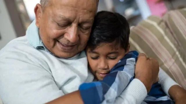 A man hugs a boy