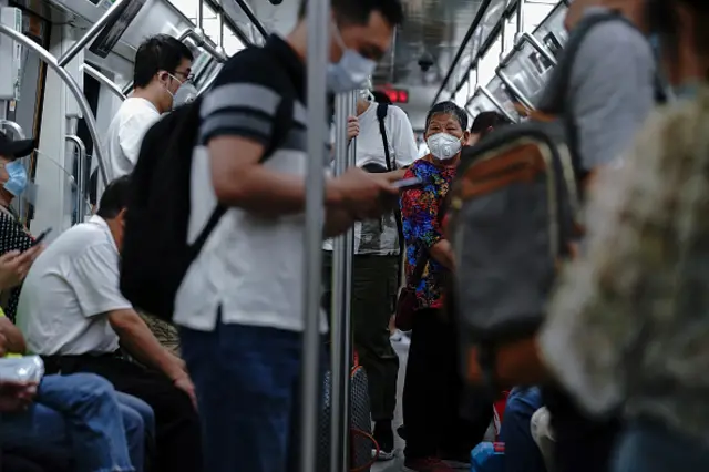 A Chinese commuter wears a protective mask as she riding the subway in Beijing,