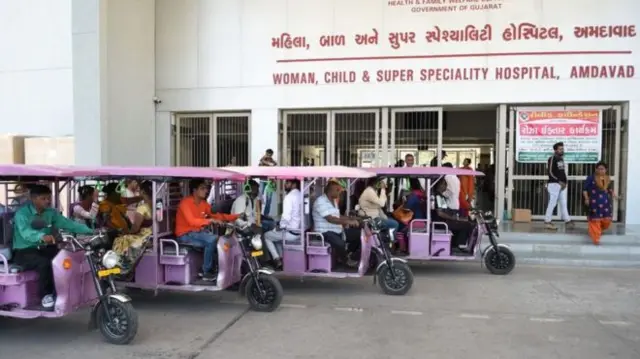 People wait outside a hospital in India