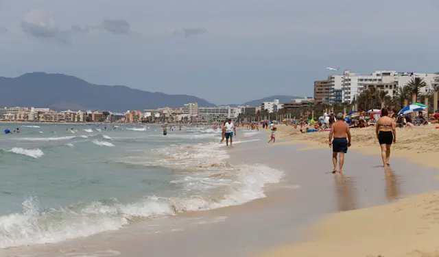 People sunbathe in playa de Palma beach in Mallorca