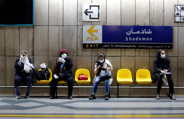 Iranian women wearing face masks wait for a train at a Tehran metro station