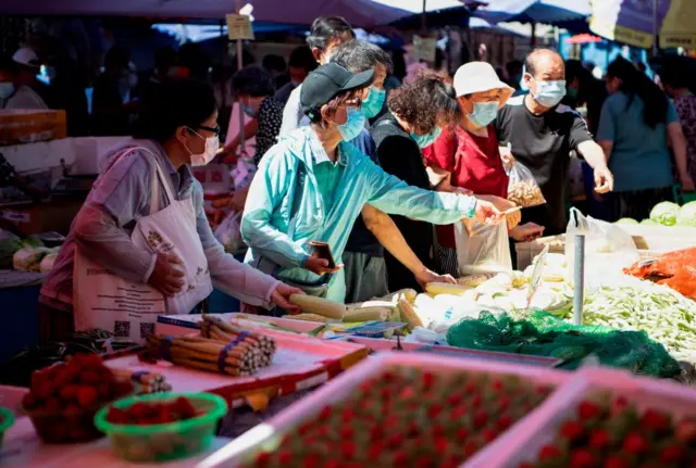 People buy groceries at the Chaowai market in Beijing on June 14, 2020.