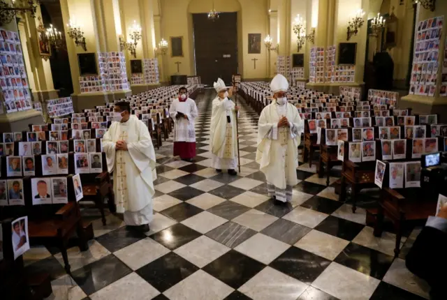 Archbishop Carlos Castillo blesses thousands of photographs of Peru's coronavirus victims