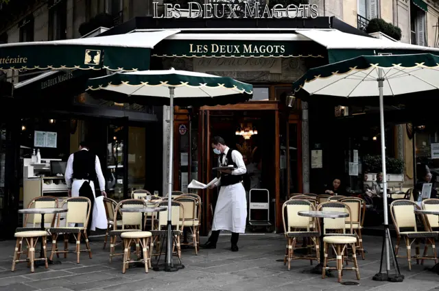 Waiters work at the terrace of a cafe in Paris, on June 15, 2020