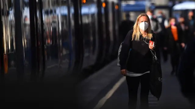 A passenger wearing a face mask at Waterloo station in London