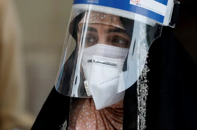 A woman wears a shield and a face mask in Karachi, Pakistan on 15 June 2020