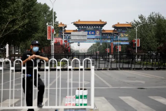 A security officer wearing a face mask is seen at a blocked entrance to the Xinfadi wholesale market, which has been closed following cases of the coronavirus disease (COVID-19) infections, in Beijing, China June 16, 2020