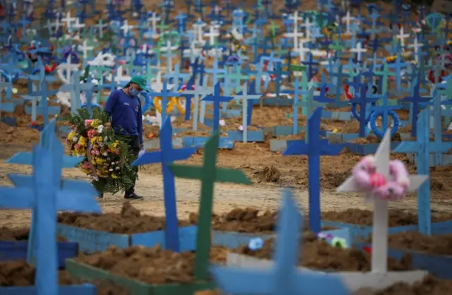 A gravedigger walks at the Parque Taruma cemetery