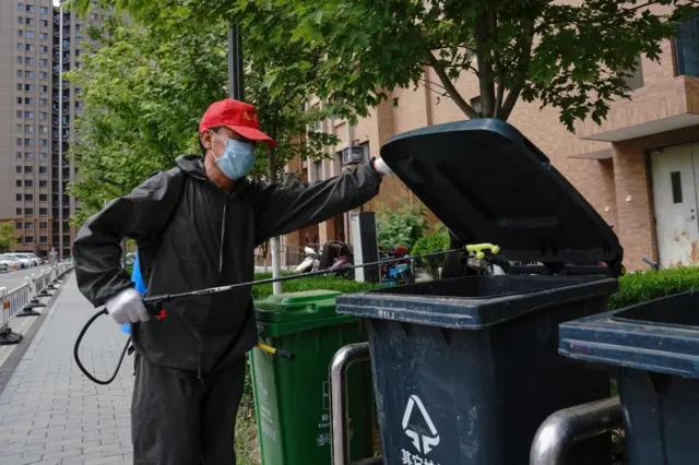 A community organisation volunteer disinfects bins at an apartment block in Beijing, China, on 16 June 2020