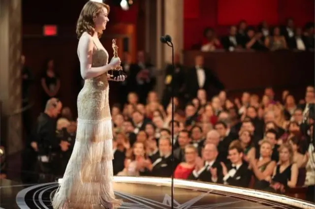 An actress holds an Oscar statuette