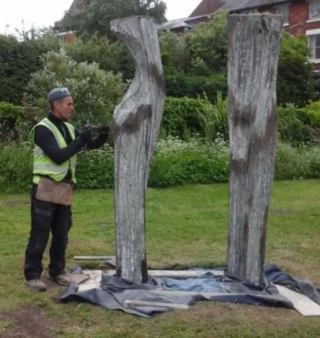 Man installing statue of the sisters