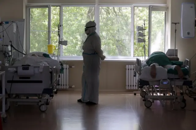 An intensive care nurse stands near her patients in a hospital in Moscow, 9 June