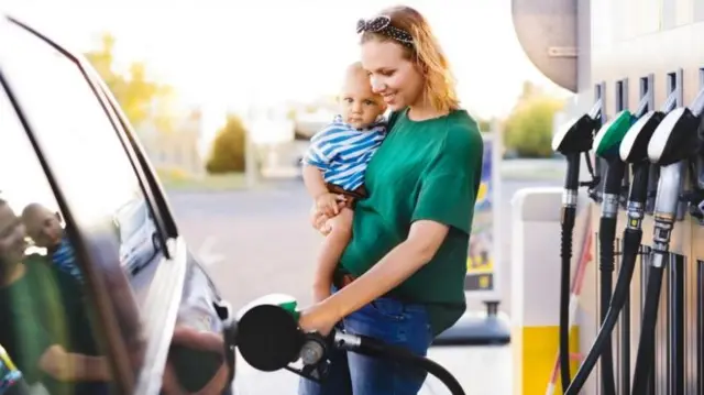 Woman and child at a fuel pump