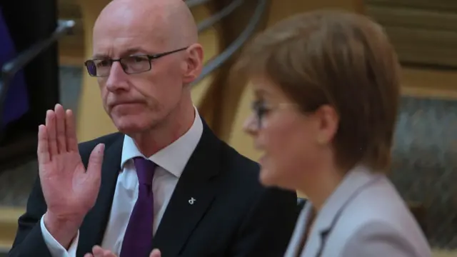 John Swinney applauds the first minister in parliament earlier today