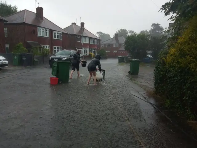 Residents removing flood water