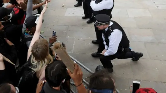 A police officer takes a knee near Downing Street earlier this month