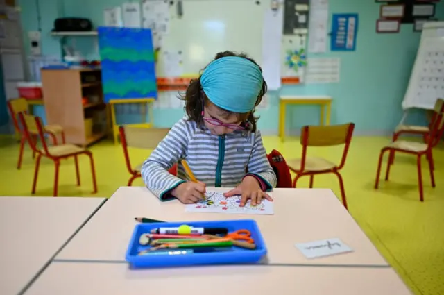 A child draws in a classroom at Champ l'Eveque public school in Bruz, western France, on May 12, 2020