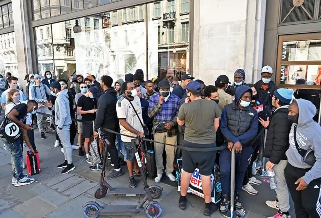 Shoppers queue outside a Nike store in London