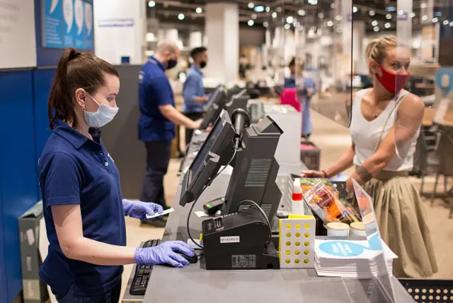 An employee wears a protective face mask as she serves customers in Russia