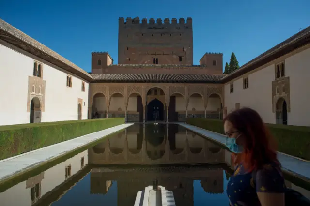 A tourist wears a mask at the Alhambra