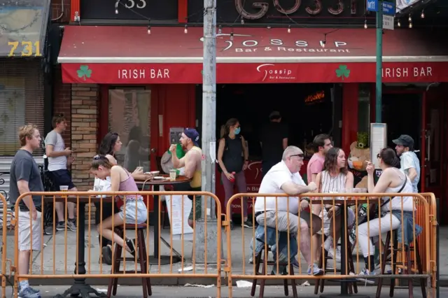 People drink outdoors at bars and restaurants in the Hells Kitchen