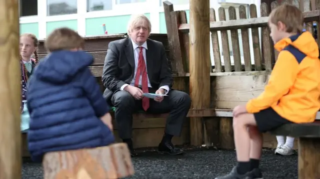 British Prime Minister Boris Johnson joins a socially distanced lesson during a visit to Bovingdon Primary School