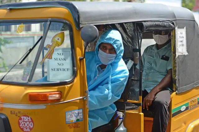 An auto driver in Chennai wearing a PPE suit and mask